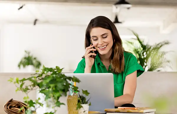 Frau im grünen Hemd telefoniert am Laptop – Werk Media Datenschutzerklärung – nordisch, klar, verlässlich