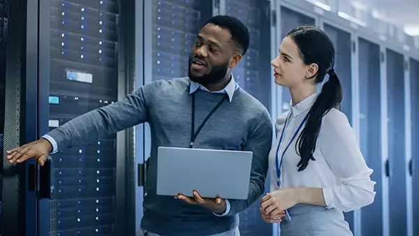 IT-Spezialisten im Rechenzentrum mit Laptop – Managed Hosting Beratung