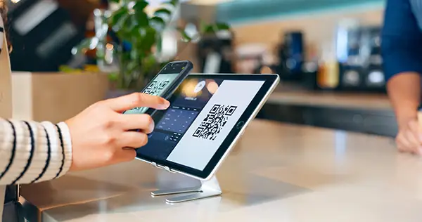 QR-Codes & NFC-Lösungen - Smartphone scannt QR-Code auf Tablet – moderne QR- und NFC-Lösung von Werk Media