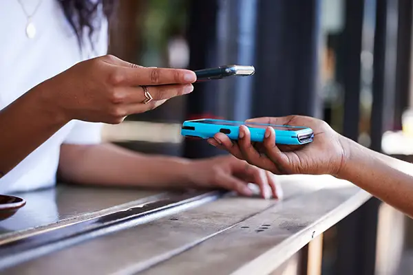 Zwei Personen halten Smartphones aneinander – digitale Visitenkarte per NFC oder QR-Code teilen